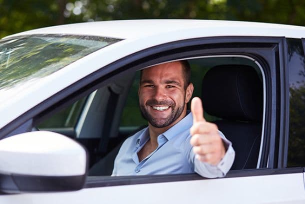 Convoyeur professionnel souriant au volant - satisfaction et réussite